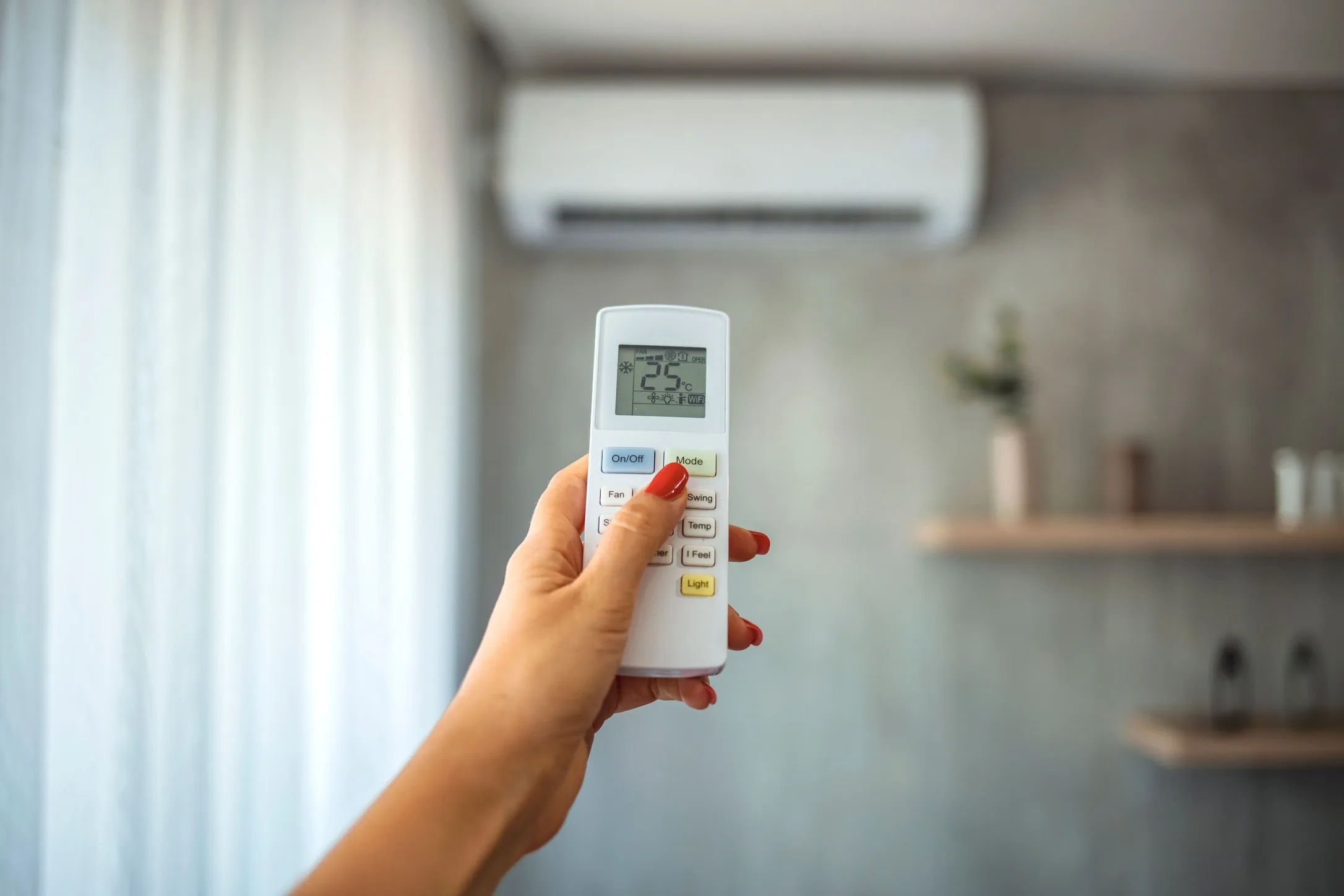 Pessoa com controle ativando o modo cool no ar-condicionado